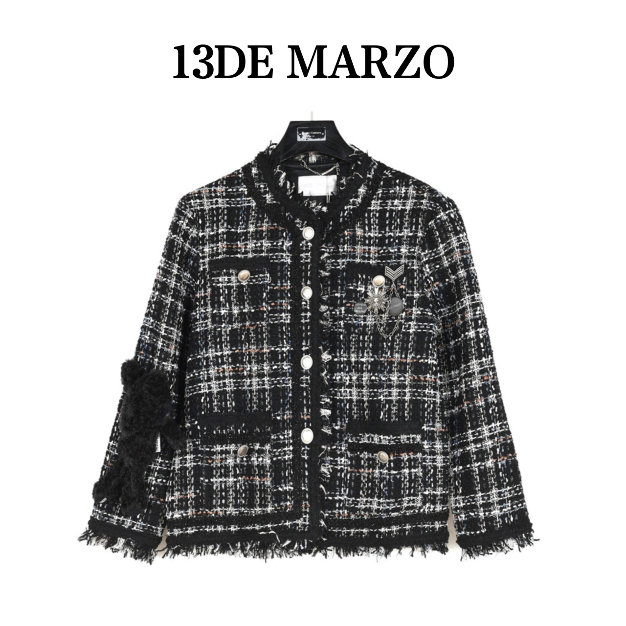 CHANEL13DEMARZO tweed jacket is crafted from classic tweed fabric, presenting a noble and elegant texture. The color scheme with black as the main tone is intertwined with white lines to form a plaid pattern, creating a rich sense of layering.