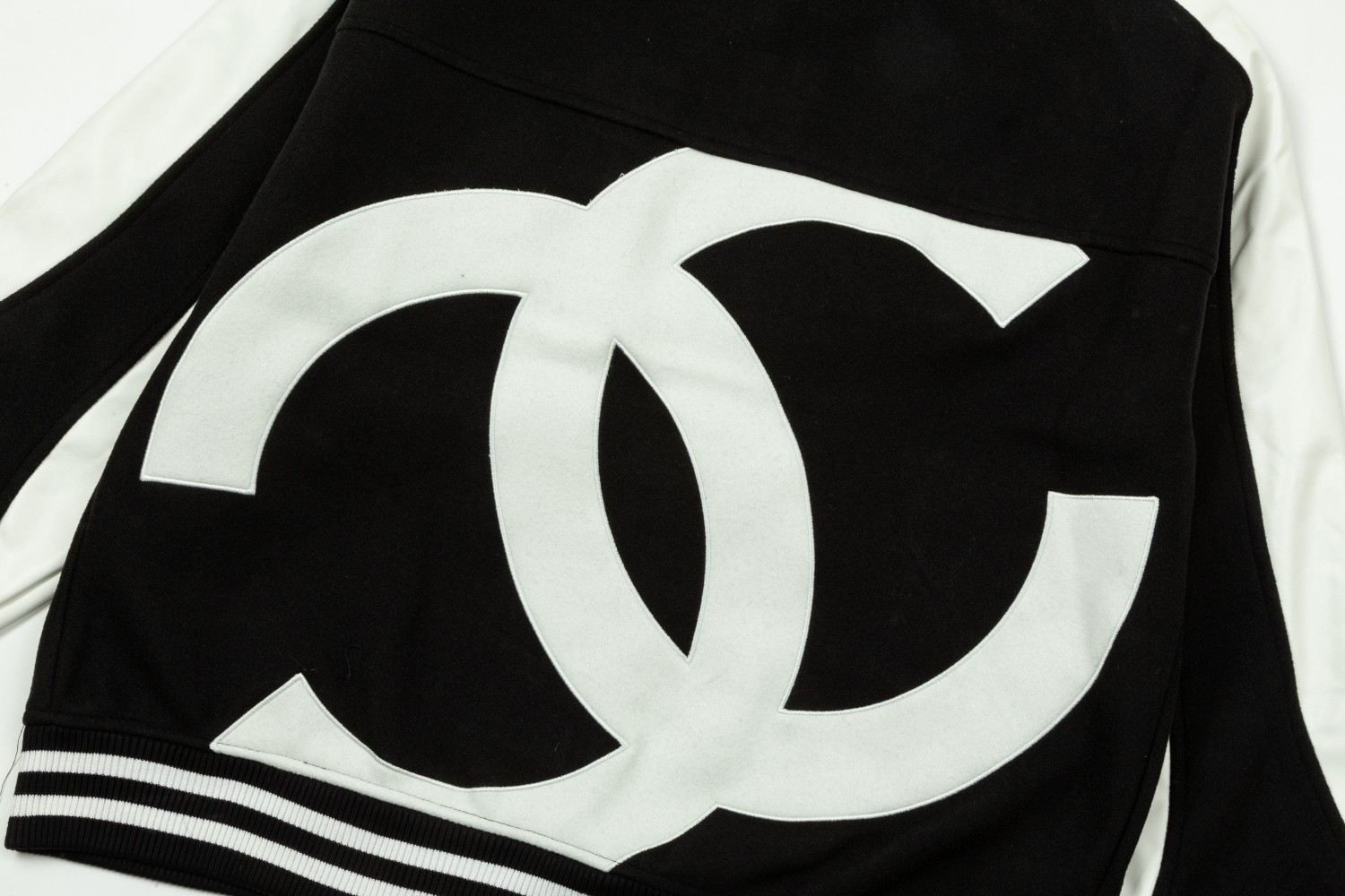 CHANEL spliced flocked embroidered baseball jacket. It has baked lacquer flat all-surface four-piece buttons (the buttons bear the logo).